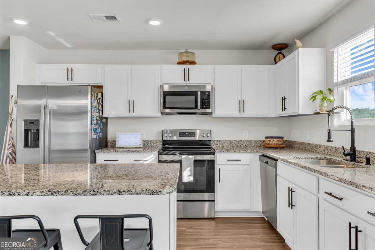 590 Wilkins Road Midway, GA 31320 - Photo 17 of 62 a kitchen with stainless steel appliances granite countertop a sink stove and refrigerator