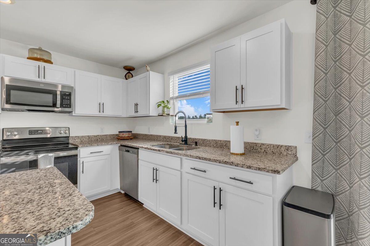 590 Wilkins Road Midway, GA 31320 - Photo 18 of 62 a kitchen with stainless steel appliances granite countertop a sink stove and microwave