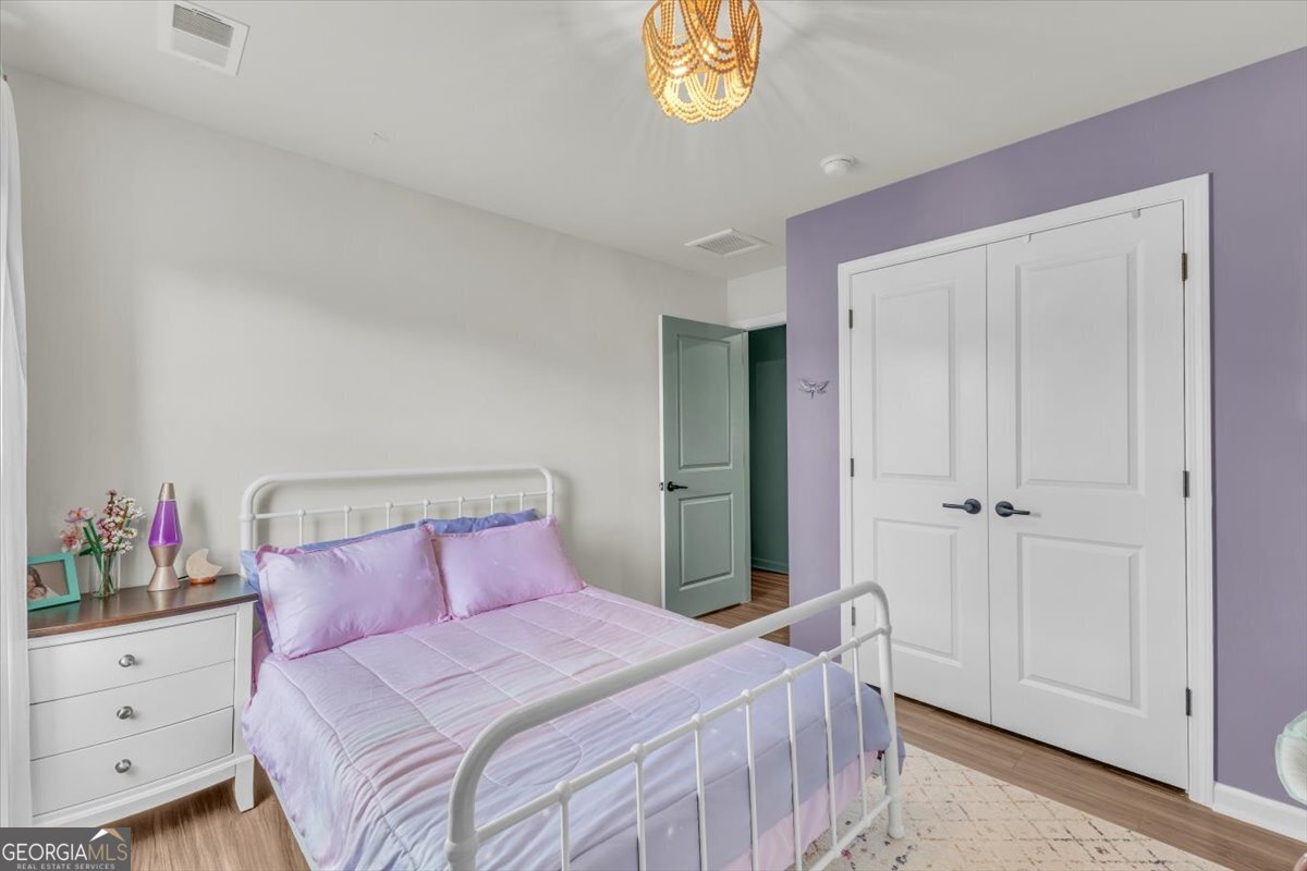 590 Wilkins Road Midway, GA 31320 - Photo 26 of 62 a bedroom with a bed and a chandelier