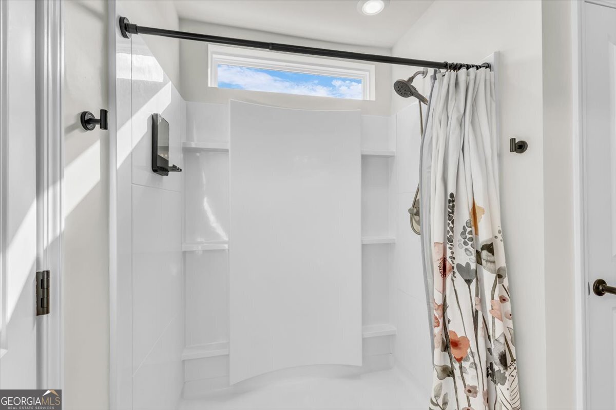 590 Wilkins Road Midway, GA 31320 - Photo 40 of 62 a bathroom with a shower and a shower curtain