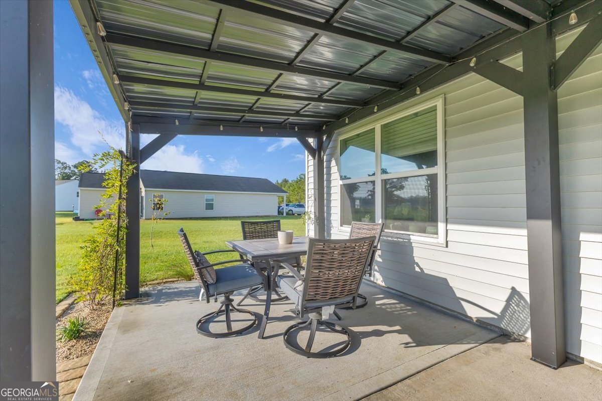 590 Wilkins Road Midway, GA 31320 - Photo 44 of 62 a view of a patio with table and chairs and potted plants