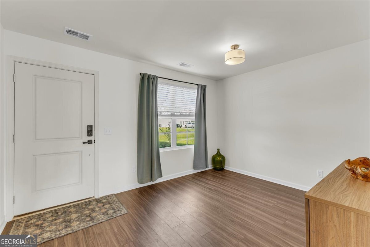 590 Wilkins Road Midway, GA 31320 - Photo 6 of 62 a view of an empty room with wooden floor and a window