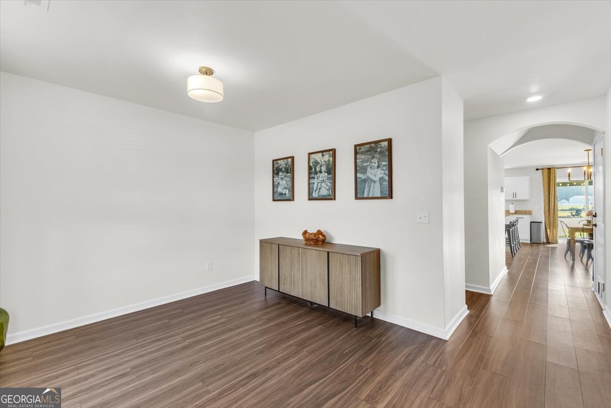 590 Wilkins Road Midway, GA 31320 - Photo 7 of 62 a view of an empty room with wooden floor and a window