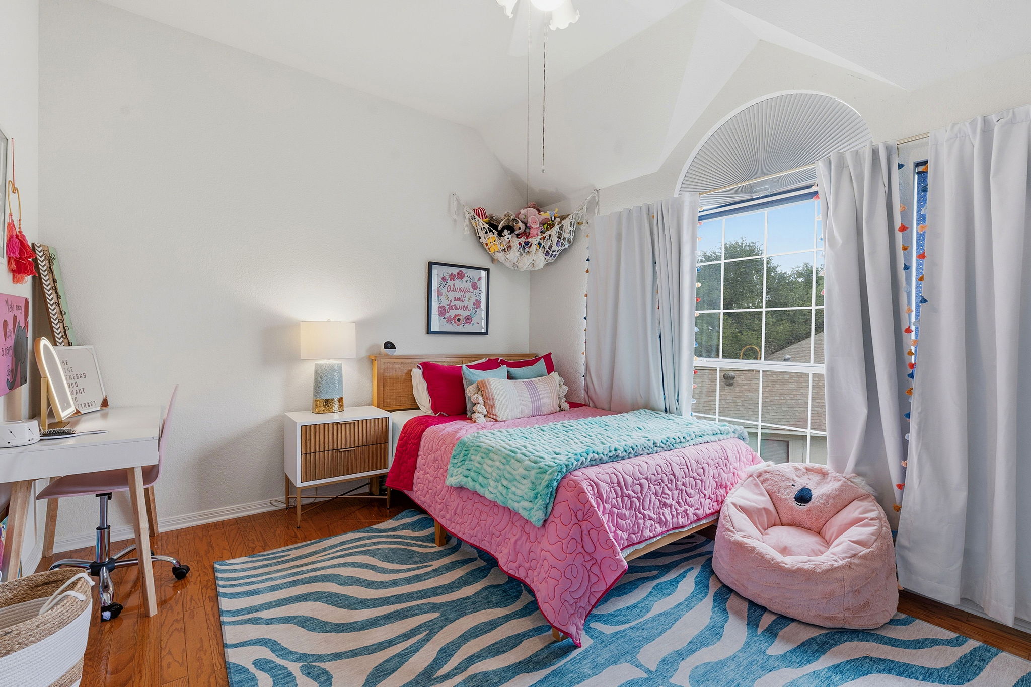 8317 Pommel Drive Austin, TX 78759 - Photo 16 of 26 Hardwood floors and soaring vaulted ceilings define this inviting and cheerful bedroom.