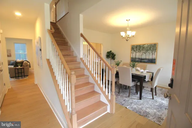 a view of a hallway to a livingroom with furniture stairs and windows