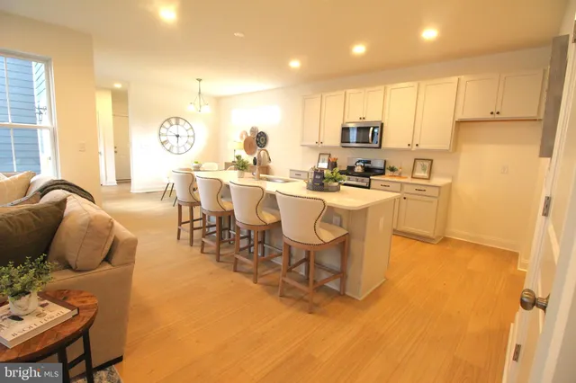 a kitchen with kitchen island granite countertop a sink cabinets and stainless steel appliances