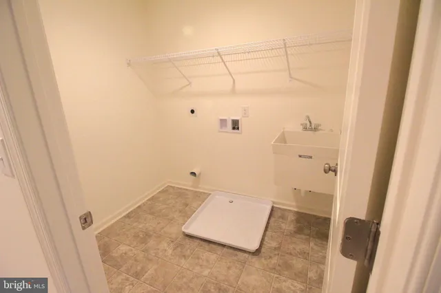 a view of an empty room with wooden floor and a bathroom