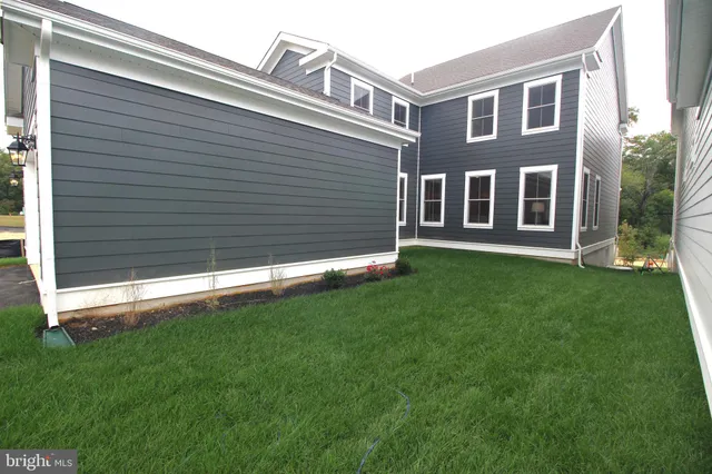 a backyard of a house with potted plants and a yard