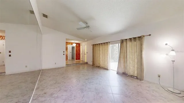 a view of a livingroom with furniture and chandelier fan