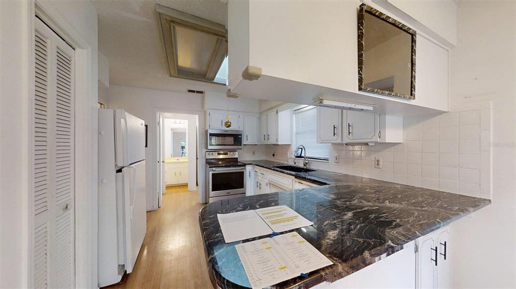 53 North Archwood Drive Inverness, FL 34450 - Photo 27 of 81 a kitchen with stainless steel appliances granite countertop a refrigerator stove oven and white cabinets