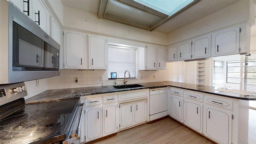 53 North Archwood Drive Inverness, FL 34450 - Photo 28 of 81 a kitchen with granite countertop white cabinets white stainless steel appliances and sink