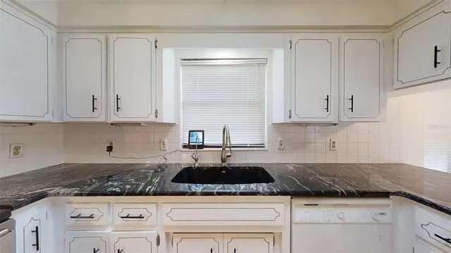 a bathroom with a granite countertop shower a sink and a mirror