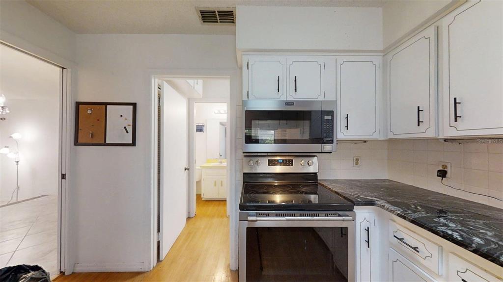 53 North Archwood Drive Inverness, FL 34450 - Photo 30 of 81 a kitchen with white cabinets and stainless steel appliances
