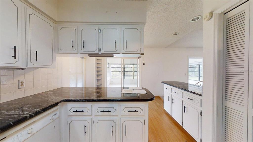 53 North Archwood Drive Inverness, FL 34450 - Photo 32 of 81 a kitchen with granite countertop white cabinets and white appliances