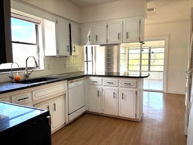 53 North Archwood Drive Inverness, FL 34450 - Photo 33 of 81 a kitchen with granite countertop white cabinets white appliances wooden floor and a window