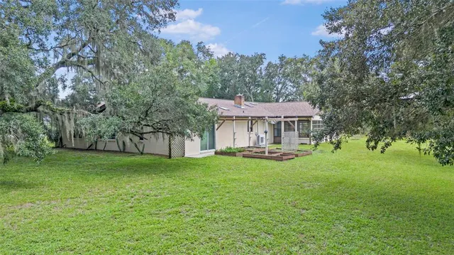 a backyard of a house with a yard and outdoor seating
