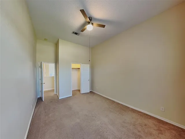 an empty room with a ceiling fan and bathroom