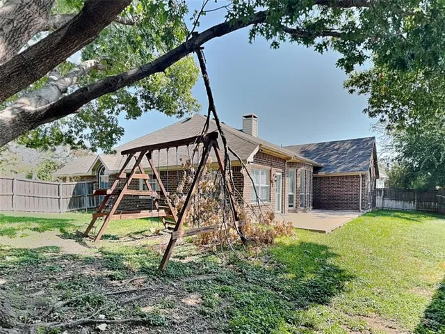 a view of a house with backyard and a tree