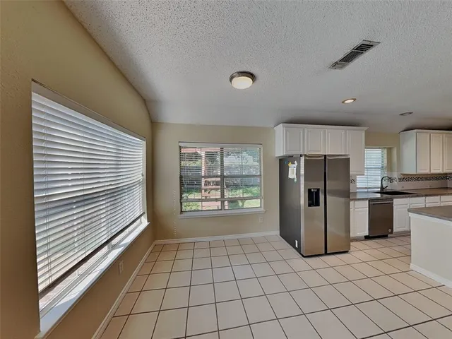 a view of a kitchen with refrigerator and windows