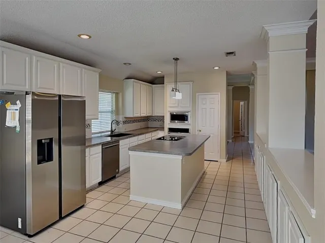 a large kitchen with stainless steel appliances a refrigerator sink and cabinets