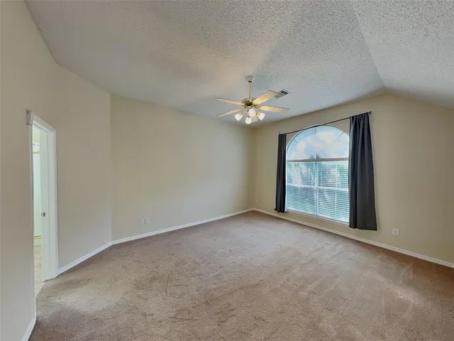 a view of an empty room with a chandelier fan
