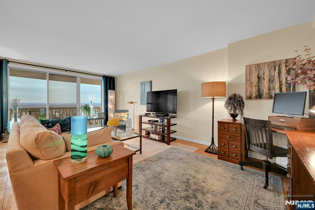 2000 Linwood Avenue, Unit 18B Fort Lee, NJ 07024 - Photo 2 of 27 a living room with furniture a flat screen tv and a large window