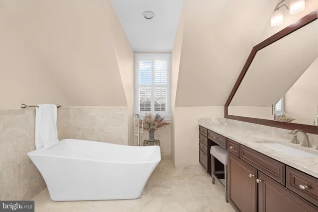 a bathroom with a tub sink and mirror