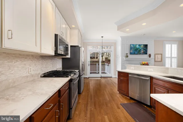 a kitchen with stainless steel appliances granite countertop a stove a sink dishwasher and a microwave oven with wooden floor