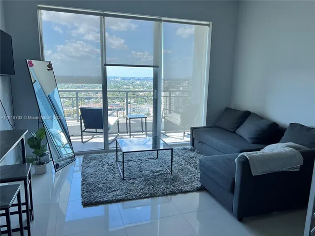 a living room with furniture and a floor to ceiling window