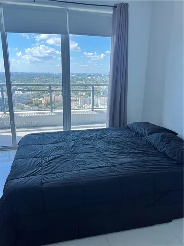 a bed sitting in a bedroom next to a window