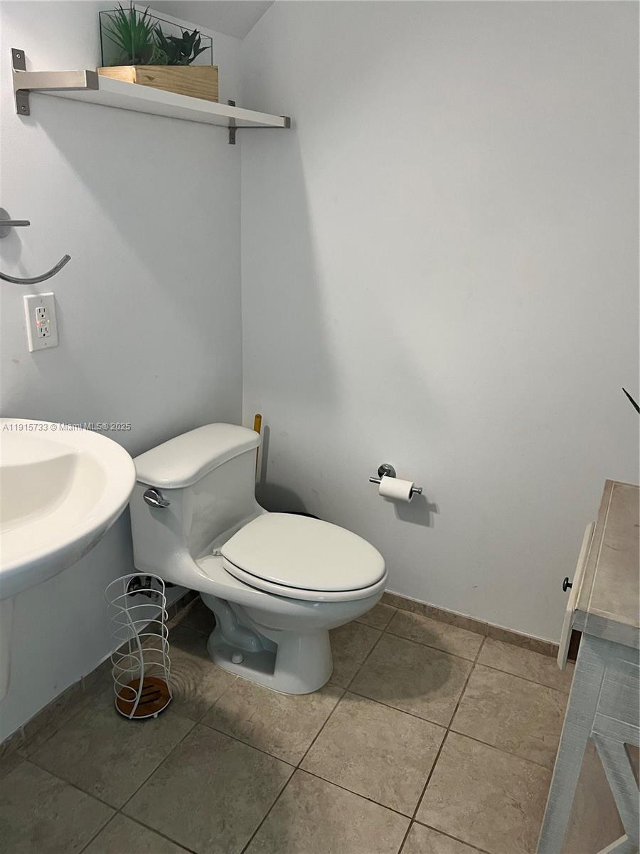 60 Southwest 13th Street, Unit 2207 Miami, FL 33130 - Photo 9 of 9 a white toilet sitting next to a white sink and vanity