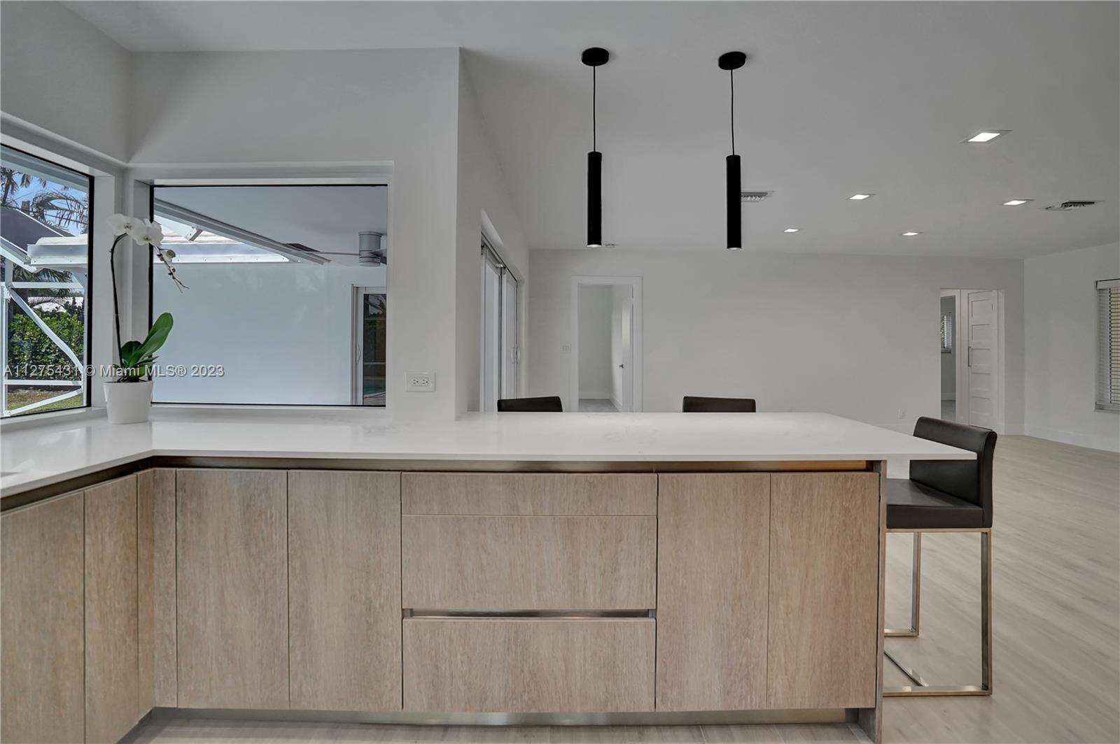 1311 Mulberry Way Boca Raton, FL 33486 - Photo 12 of 45 a view of a kitchen with kitchen island a large counter top space a sink and appliances