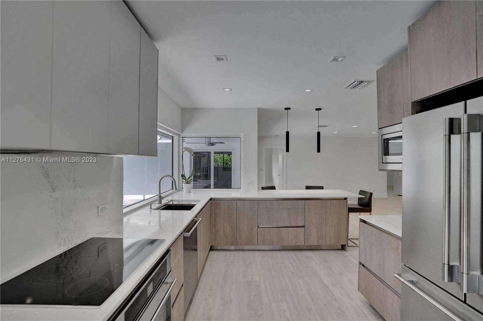 1311 Mulberry Way Boca Raton, FL 33486 - Photo 16 of 45 a large kitchen with stainless steel appliances a sink and cabinets