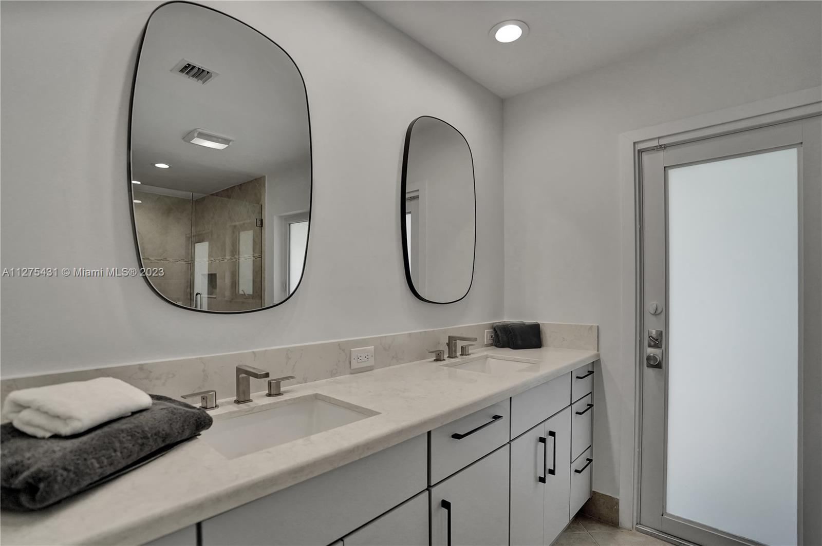 1311 Mulberry Way Boca Raton, FL 33486 - Photo 20 of 45 a bathroom with a double vanity sink and a mirror