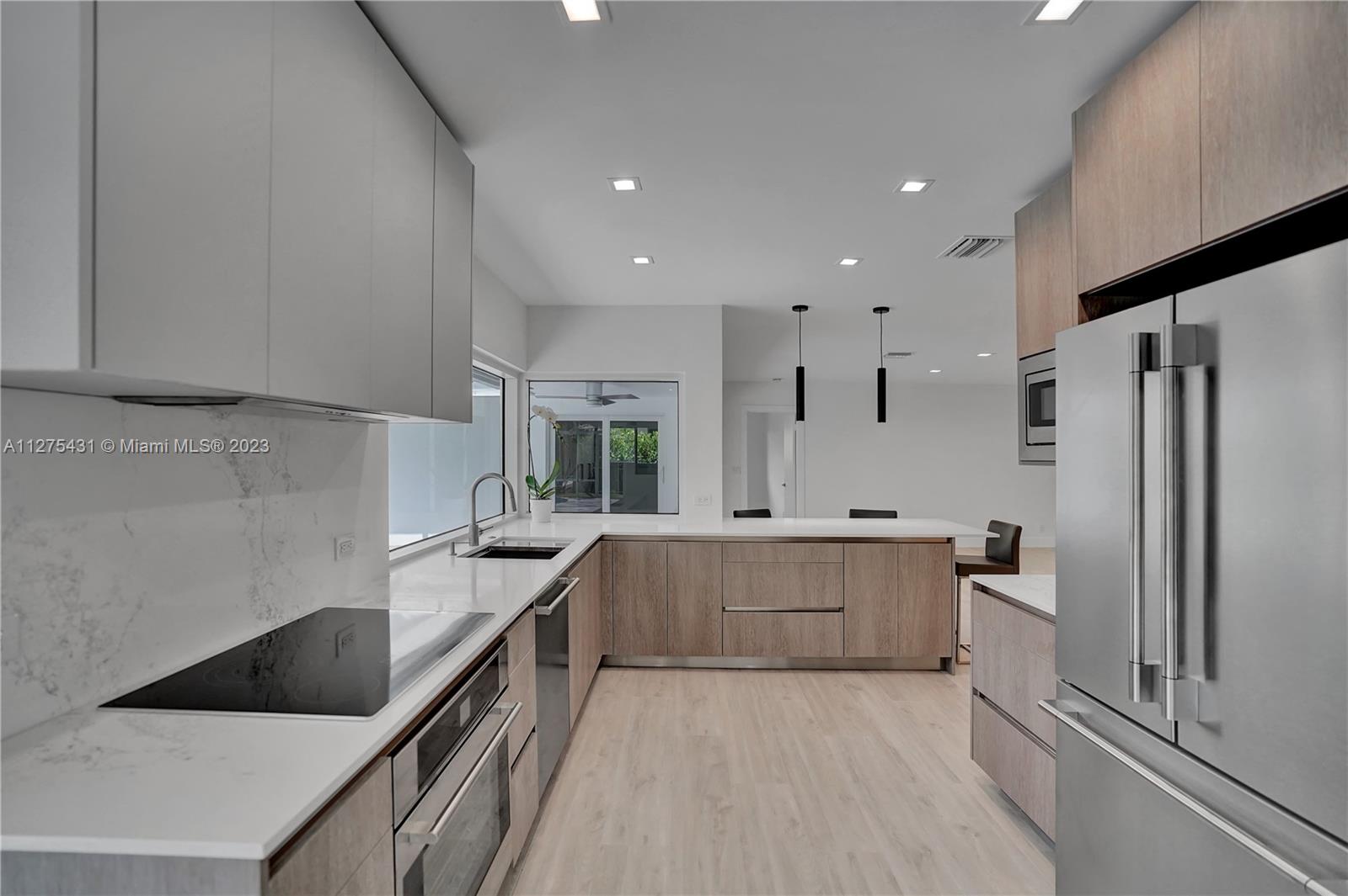 1311 Mulberry Way Boca Raton, FL 33486 - Photo 5 of 45 a large kitchen with stainless steel appliances kitchen island a large counter top and a refrigerator