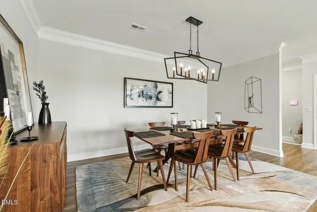 a kitchen with stainless steel appliances kitchen island granite countertop a dining table chairs sink and cabinets