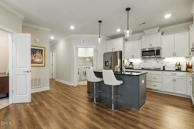 a kitchen with granite countertop white cabinets stainless steel appliances and a window