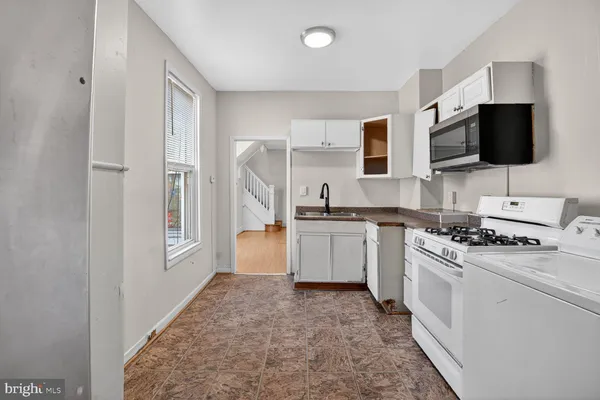 a kitchen with a stove top oven a sink dishwasher and a refrigerator with wooden floor