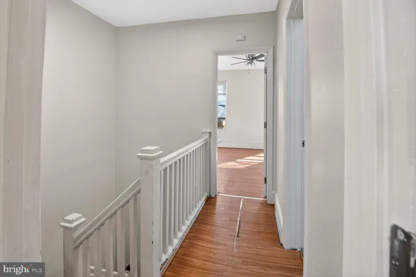 a view of a hallway with wooden floor and staircase