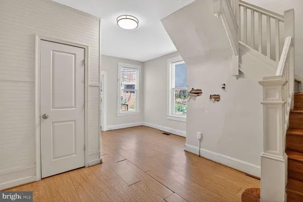 an empty room with wooden floor and windows
