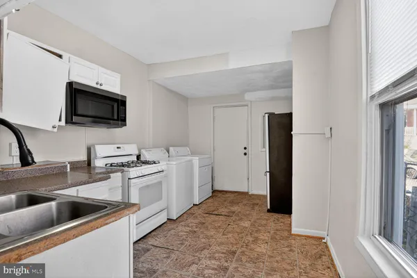 a view of a kitchen with a sink and a refrigerator
