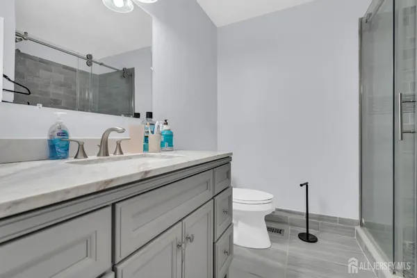 a bathroom with a sink a toilet and a mirror