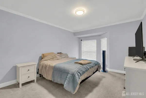 a bedroom with a bed and a flat tv screen on dresser