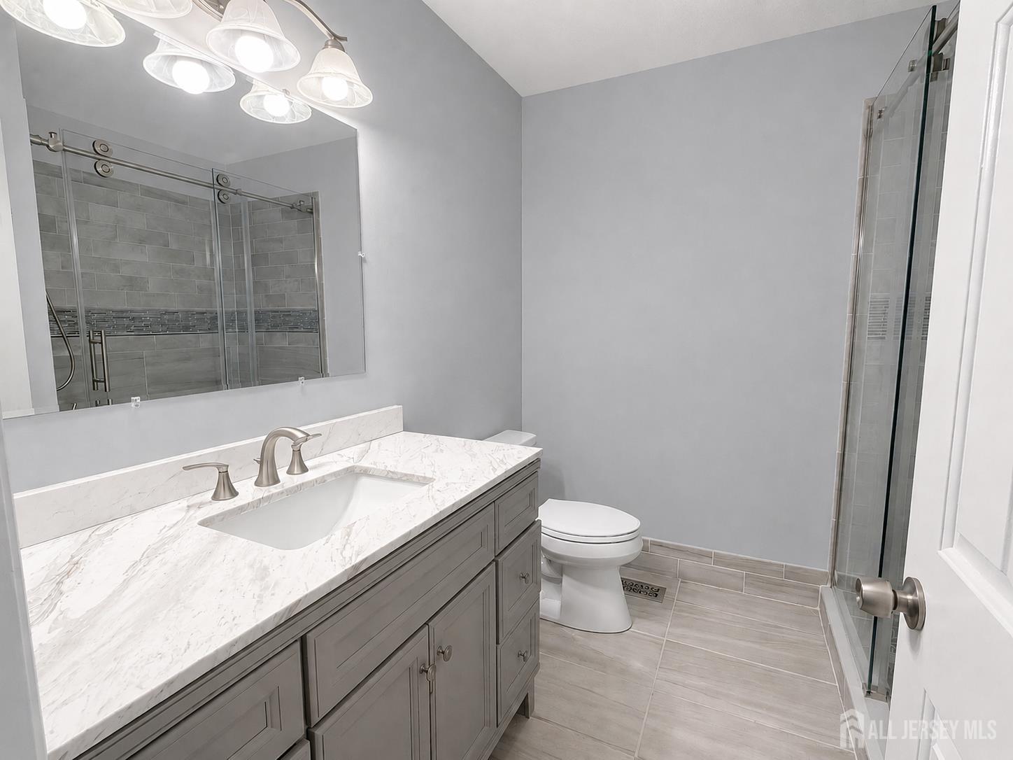 91 Delaware Lane Somerville, NJ 08876 - Photo 18 of 33 a bathroom with a granite countertop sink a toilet and a mirror