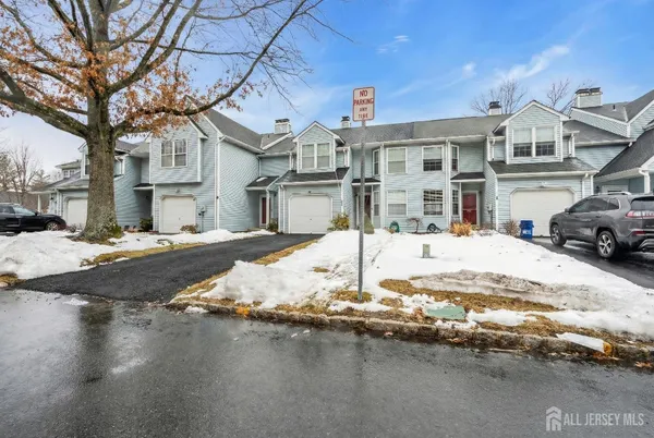 a view of a white house with a yard covered with snow