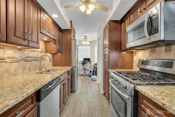 a kitchen with stainless steel appliances granite countertop a sink stove and refrigerator