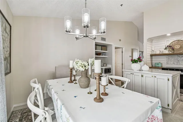 a kitchen with stainless steel appliances kitchen island granite countertop a table chairs and a stove