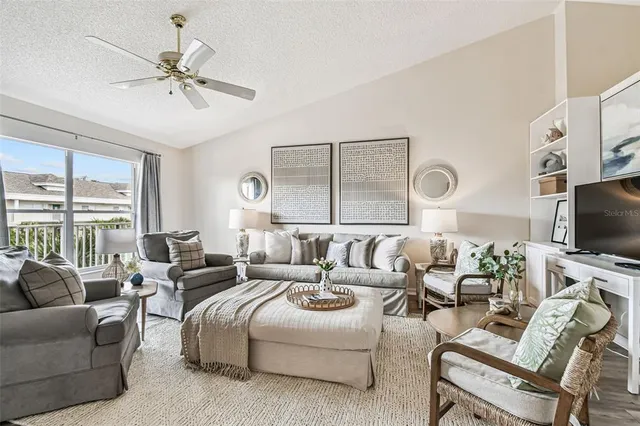 a living room with furniture a large window and a flat screen tv