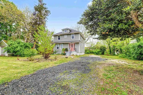 a view of a house with a yard and sitting area