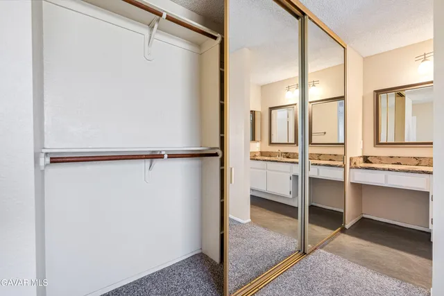 a view of walk in closet with empty racks